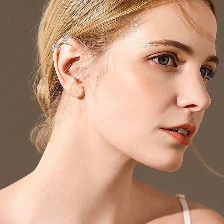 a woman wearing a pair of ear piercings on her left ear and looking off to the side