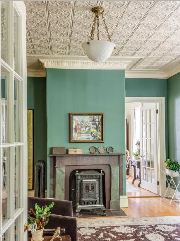 a living room with green walls and a fireplace