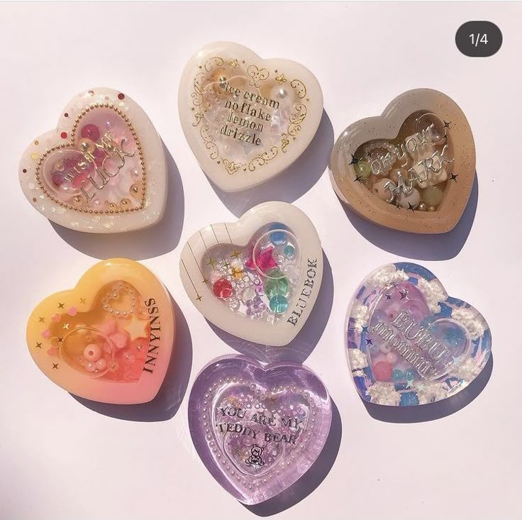 five heart shaped candy boxes with different designs on them, all decorated in pastel colors