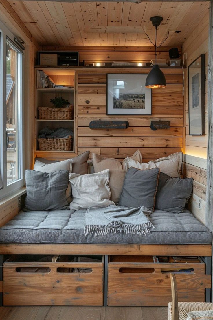 a couch with some pillows on top of it in a room filled with wooden shelves