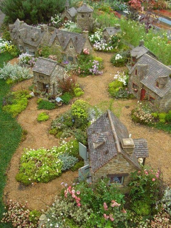 a miniature garden with lots of flowers and houses