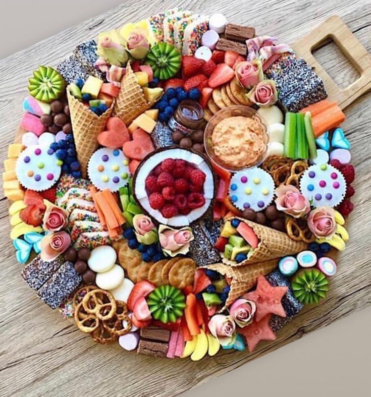 a platter filled with lots of different types of food on top of a wooden table