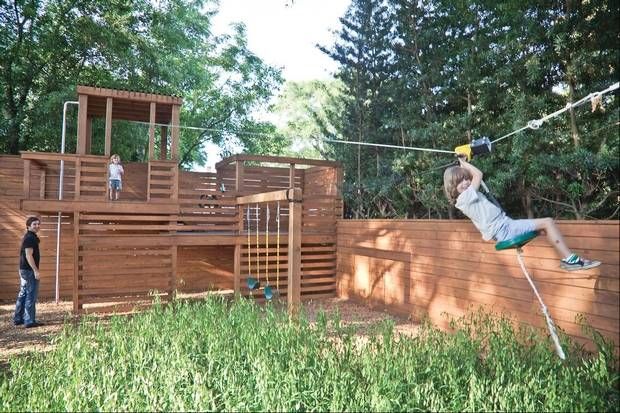 a man is swinging on a rope in the yard