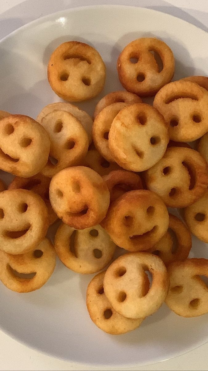 a white plate topped with smiley face cookies