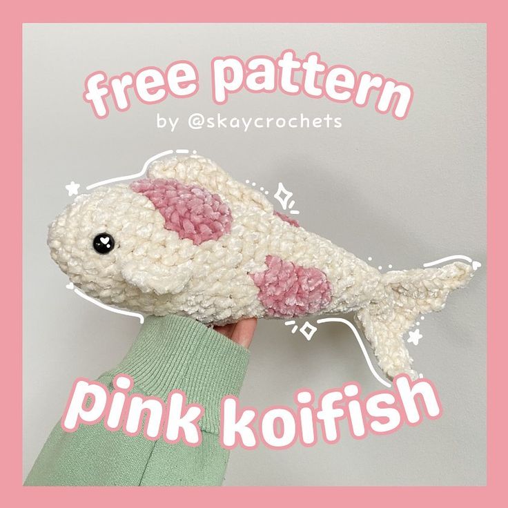 a hand holding a pink koi fish with the text free pattern by okaycrochets