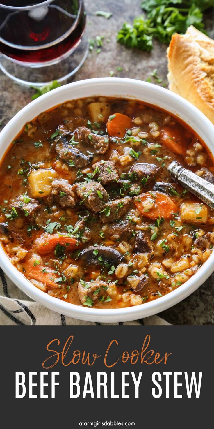 slow cooker beef and barley stew in a white bowl with bread on the side