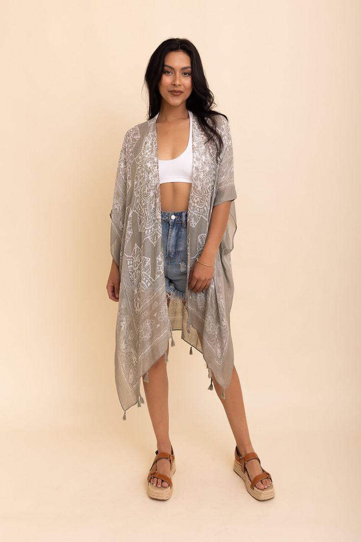 Update your vacation wardrobe with the stylish Mandala Tassel Kimono. This cute kimono will give you a cool, trendy look that's perfect for any beach destination or sunny getaway. Whether you pair it up with simple shorts or show off your feminine shape with a skirt, this kimono is sure to make you look and feel completely adorable. Showcasing beautiful colors and tassels, the Mandala Tassel Kimono is definitely the quintessential must-have item of the season! #lovemyleto 100% Viscose Imported Lightweight Beach Season Cover-up, Beachy Cover-up With Kimono Sleeves For Festivals, Lightweight Spring Beachwear Cover-up, Bohemian Lightweight Cover-up For Day Out, One Size Long Cover-up For Day Out, Summer Beach Cover-up Kimono, Casual Beach Cover-up With Tassels, Casual Vacation Cover-up With Tassels, Chic Beach Season Cover-up With Open Front