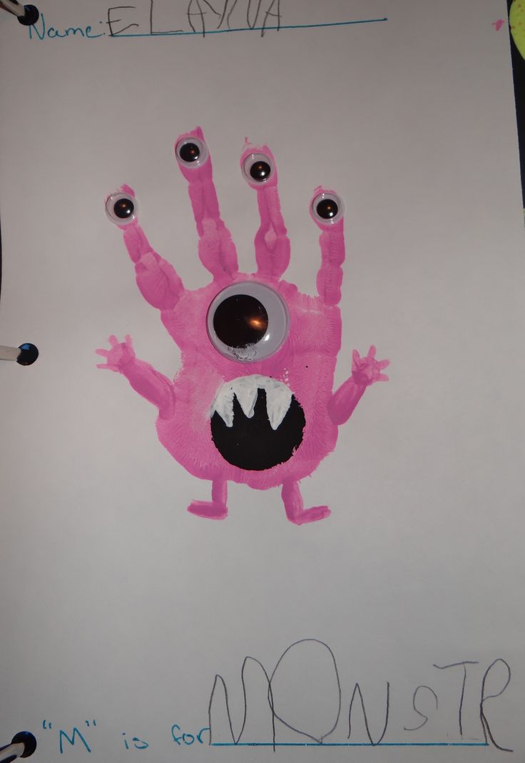 a pink monster handprint on a white paper with black eyes and one eye missing