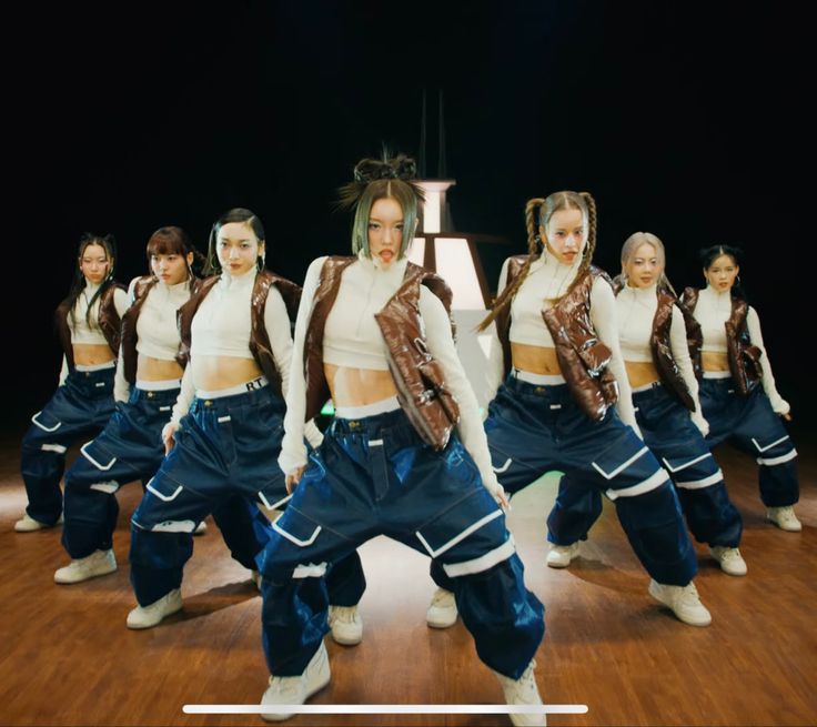 a group of young women standing on top of a wooden floor next to each other