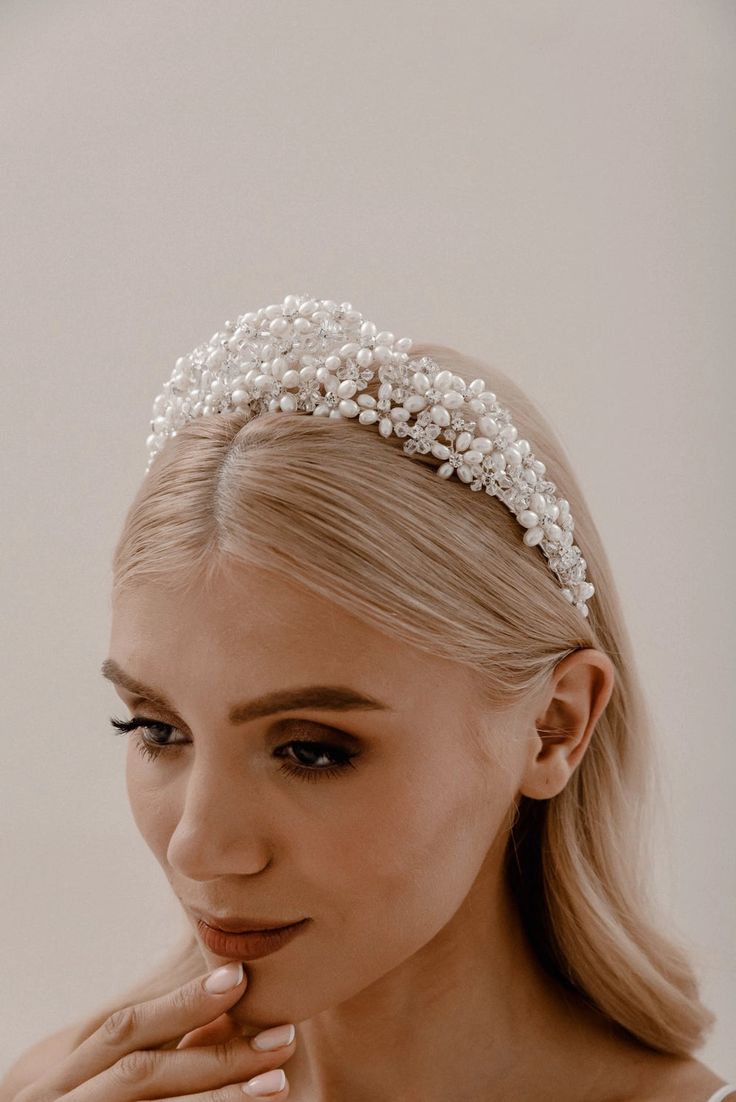 Pearl Regalia Headband Elevate your bridal hairstyle with Pearl Regalia Headband, featuring clear glass and pearls. This accessory adds a touch of timeless elegance to any wedding day look, with delicate detailing that sparkles in the light. Whether you're wearing your hair up or down, this headband is the perfect finishing touch to complete your bridal ensemble. Pearl Bridal Headband With Veil, White Crown Jewelry For Wedding, Adjustable Pearl Bridal Accessories For Wedding, Elegant Adjustable Crown For Wedding, Elegant Teardrop Crown For Wedding, Elegant Wedding Crown With Teardrop Shape, Pearl White Pearl Bridal Accessories, Elegant Silver Crown Headband, Elegant Teardrop Crown Wedding Headpiece