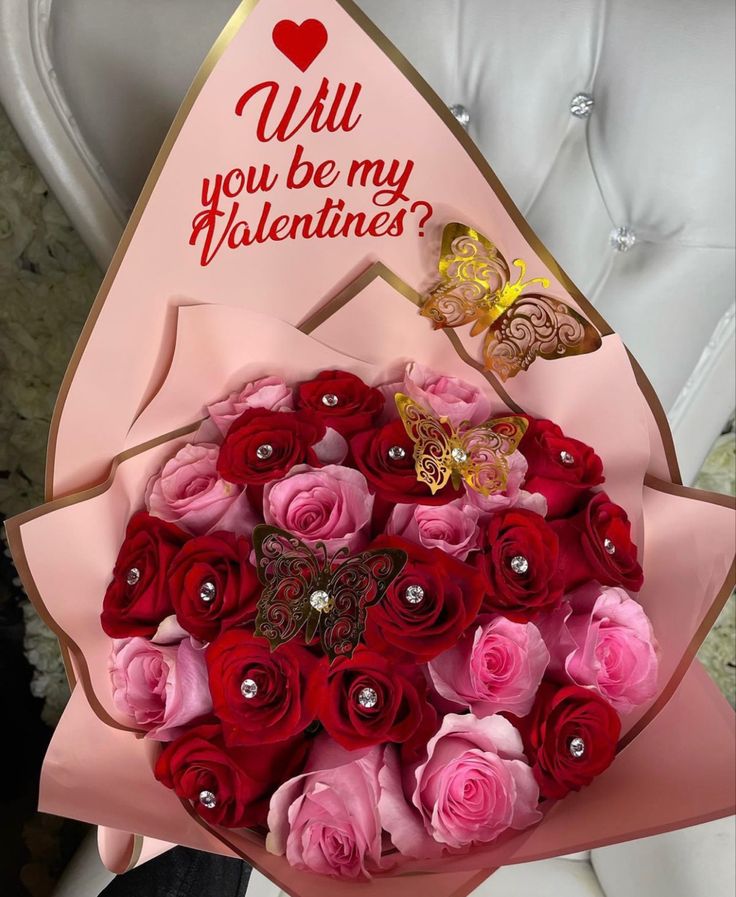 a bouquet of red and pink roses with a butterfly on top that says will you be my valentine?