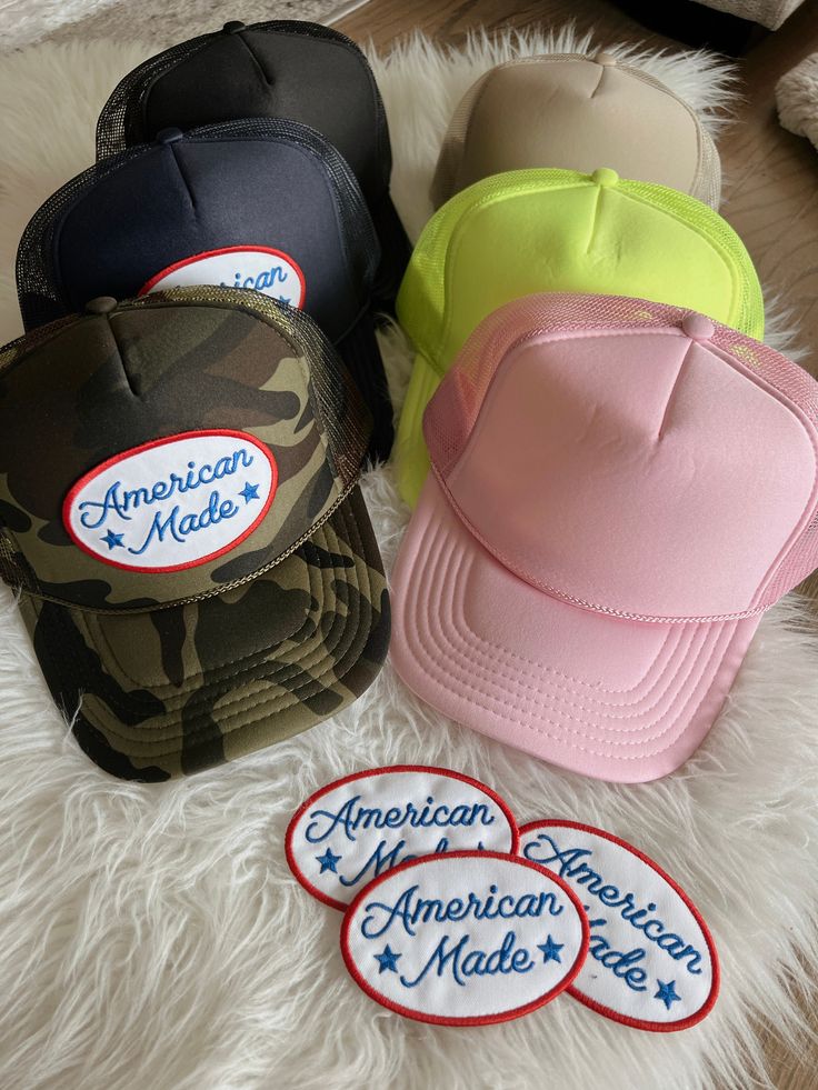 Camo, khaki, navy, light pink, or neon yellow high crown foam snap back trucker hat detailed with American Made patch Flat Brim Trucker Hat With Embroidered Patch For Streetwear, Streetwear Trucker Hat With Embroidered Patch And Flat Brim, Trucker Snapback Hat With Patches For Streetwear, Trucker Style Snapback Hat With Patches For Streetwear, Summer Streetwear Trucker Hat With Logo Patch, Trendy Snapback Hat With Logo Patch For Streetwear, Trendy Trucker Hat With Embroidered Patch Snapback, Summer Snapback Hat With Logo Patch And Flat Brim, Trendy Trucker Hat With Embroidered Patch