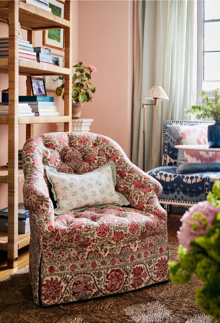 a living room filled with furniture and flowers in vases on the floor next to a bookshelf