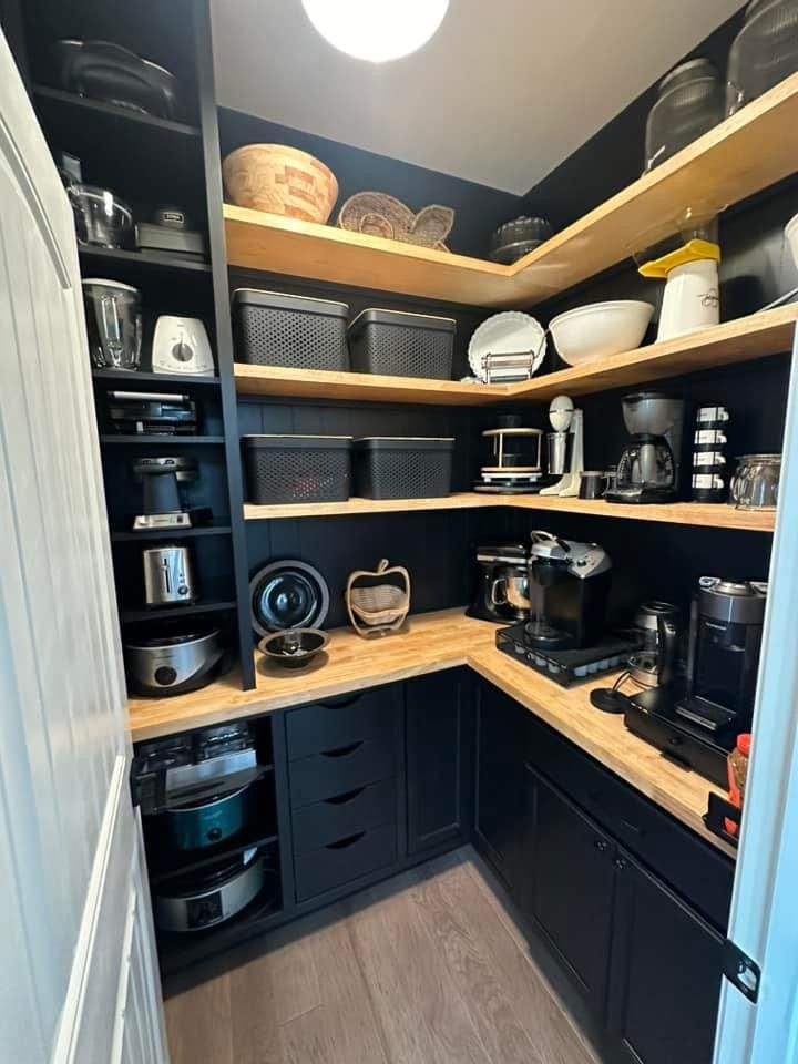 an open pantry with lots of pots and pans on the shelves next to each other