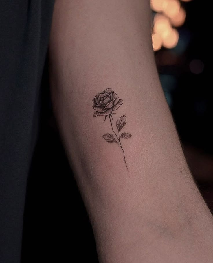 a single rose tattoo on the left arm