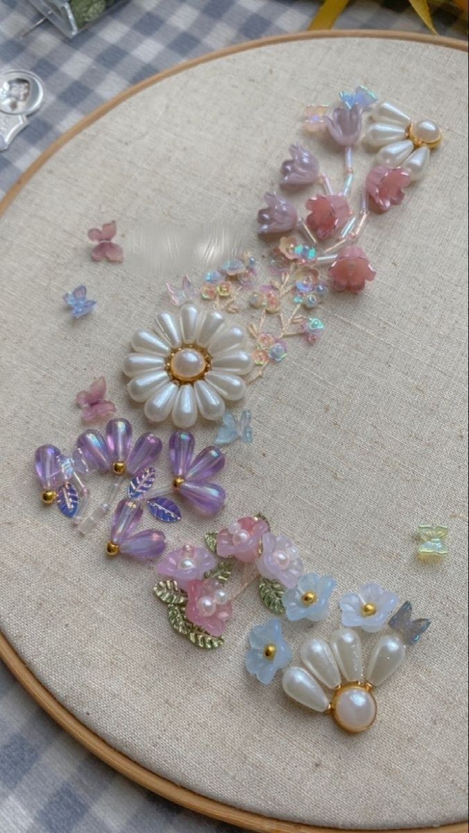 a close up of a embroidery on a table with flowers and butterflies in it's center