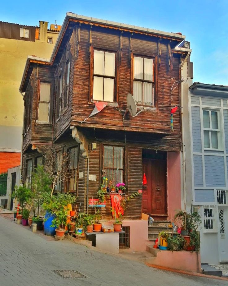 an old wooden house with potted plants in front