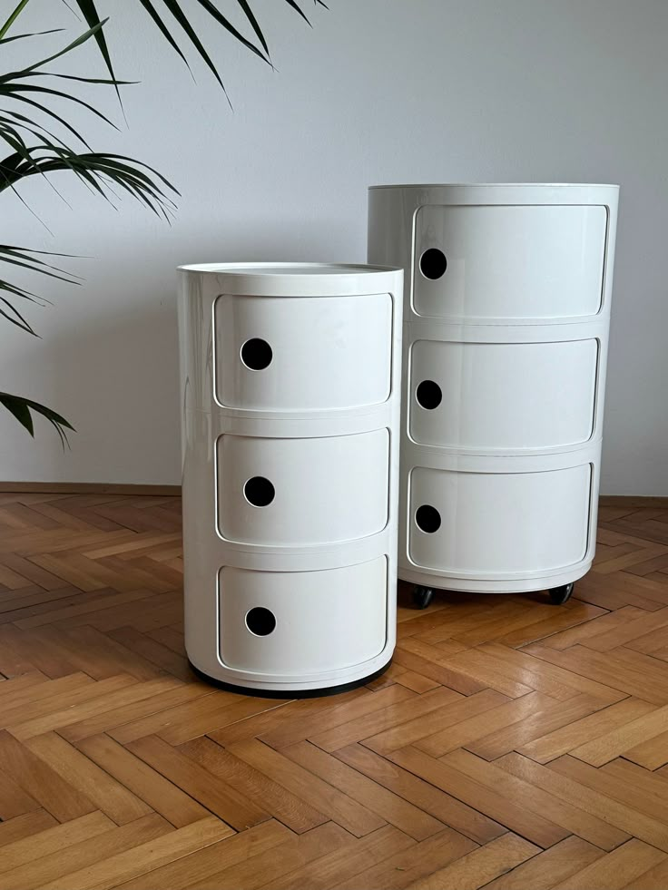 two white drawers sitting on top of a wooden floor