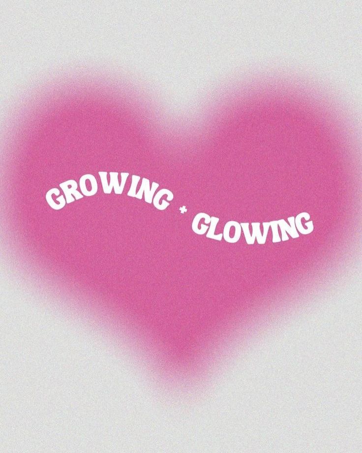 a pink heart with the words growing and glowing in white letters on it