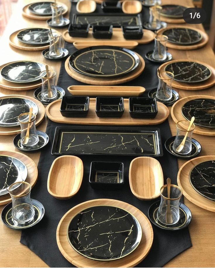 the table is set with black and gold plates