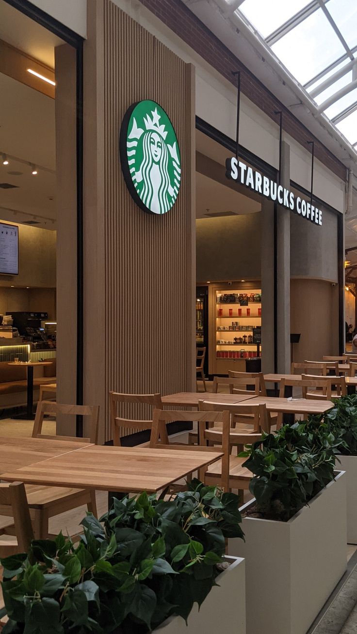 there are many tables and benches in the starbucks coffee shop that is open for business