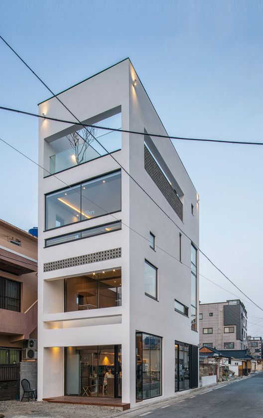 an apartment building with glass balconies on the upper floor and second story windows