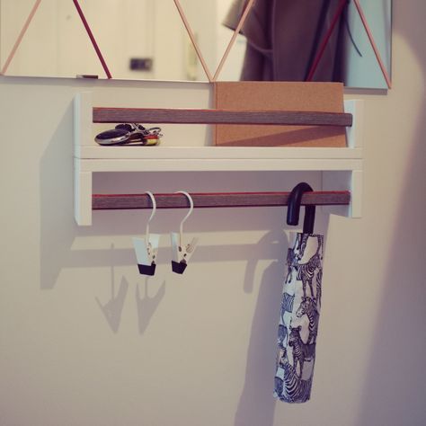 an umbrella is hanging on the wall next to some earring holders and a mirror