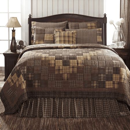 a bed with brown and tan plaid comforter set