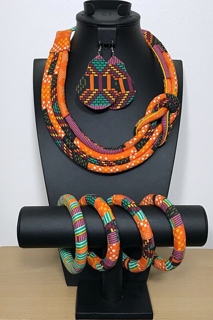 These are African print Ankara jewelry sets made with traditional Bamileke Abara print from the Bamileke tribe in Cameroon. This necklace doesn’t need much, put it over a simple slip dress and you are the talk of the whole party. This is a true conversation starter.Each set includes a 1 necklace, 1 pair of earrings and 4 small bangle bracelets- Necklace is tied behind the neck- Earrings have different shapes. You can receive one of the shape in the pictures or a different one: Heart, losange, Af Orange Fair Trade Jewelry Gift, Fair Trade Orange Jewelry Gift, Traditional Handmade Multicolor Jewelry Sets, Multicolor Fair Trade Festive Jewelry, Handwoven Jewelry For Festivals As A Gift, Adjustable Round Multicolor Jewelry Sets, Traditional Multicolor Fair Trade Jewelry, Handmade Jewelry For Traditional Ceremonies, Bohemian Fair Trade Orange Jewelry