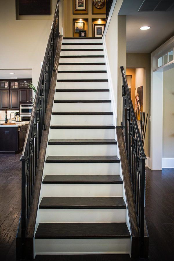 a staircase with black and white steps leading to an open floor plan in a home