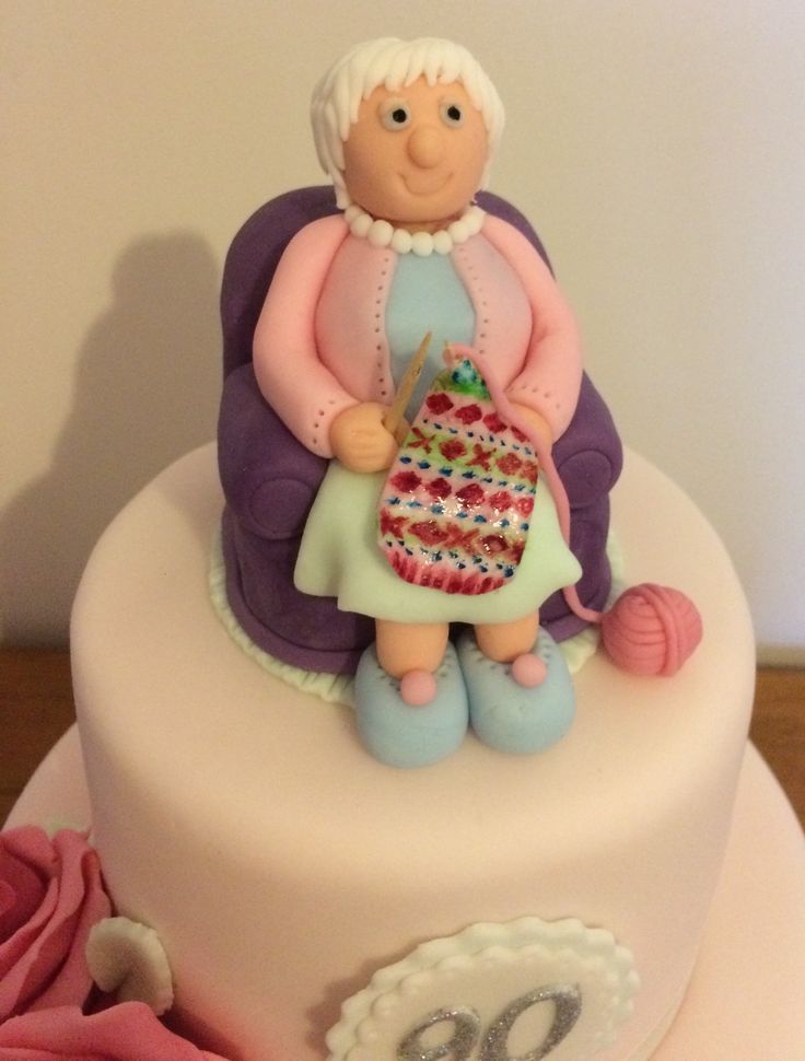 a cake decorated with an older woman knitting