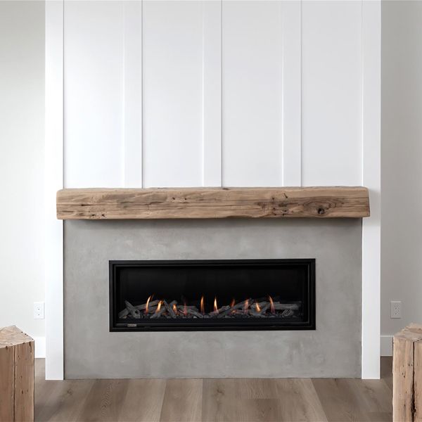 a fire place in the middle of a room with white walls and wood flooring