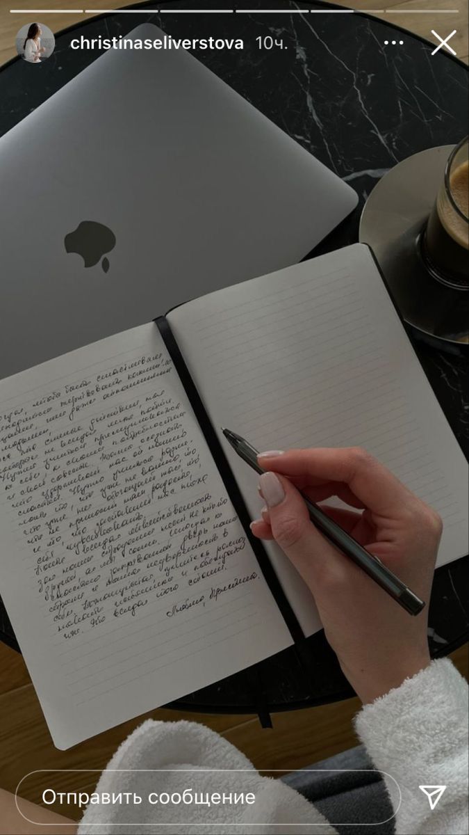 a person is writing on an open notebook