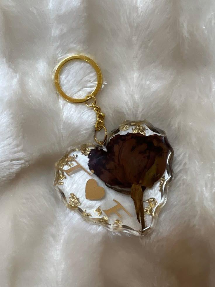 a heart shaped keychain on top of a white furnishing with gold hearts