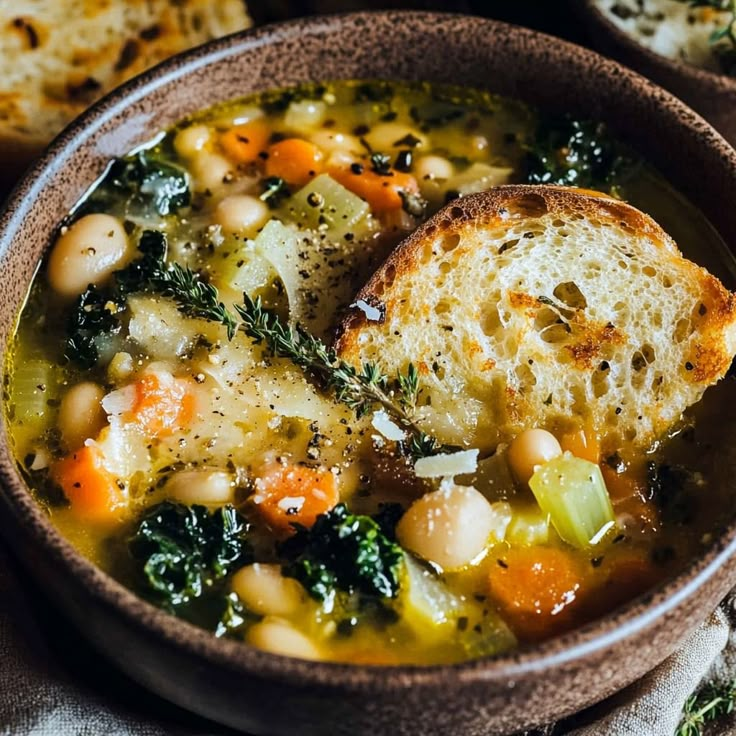 a bowl filled with soup and bread on top of a table