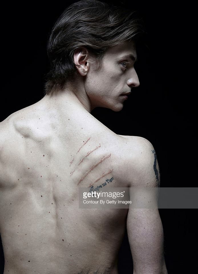 a man with tattoos on his back and chest, looking to the side stock photo