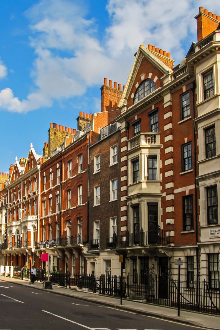 a row of buildings on the corner of a street with a blue sky in the background