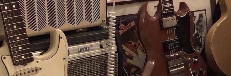 guitars and amps are lined up on the wall