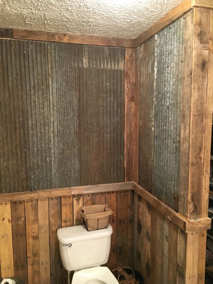 a toilet in a bathroom with wooden walls