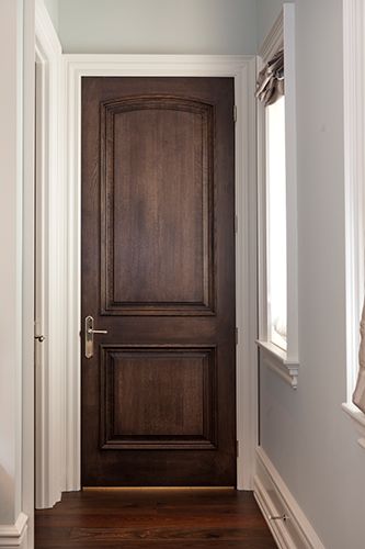 an empty hallway with a wooden door and window