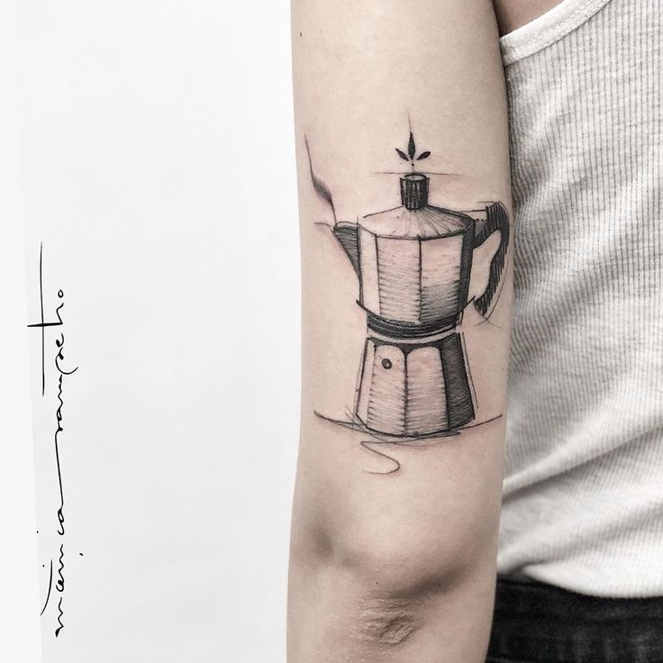 a black and white photo of a coffee maker tattoo on the left upper half of the arm