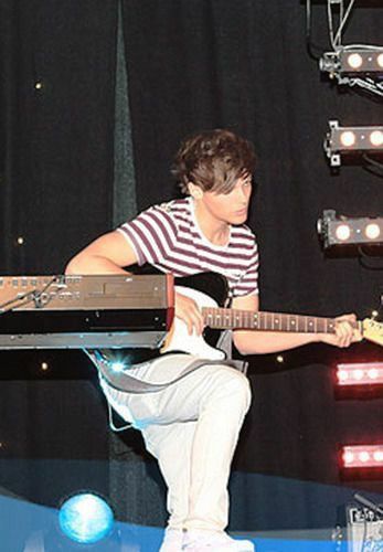 a young man playing an electric guitar on stage