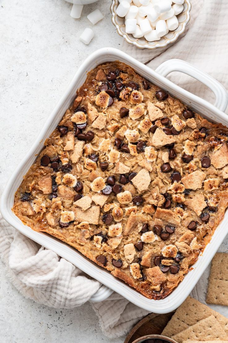 a casserole dish with marshmallows, chocolate chips and graham crackers