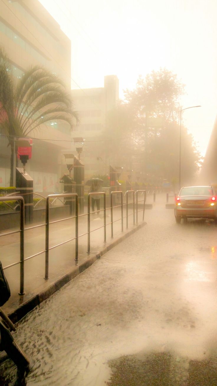 a car driving down a street in the rain