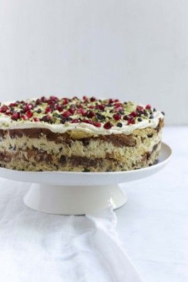 a cake with white frosting and cranberries on top sitting on a plate