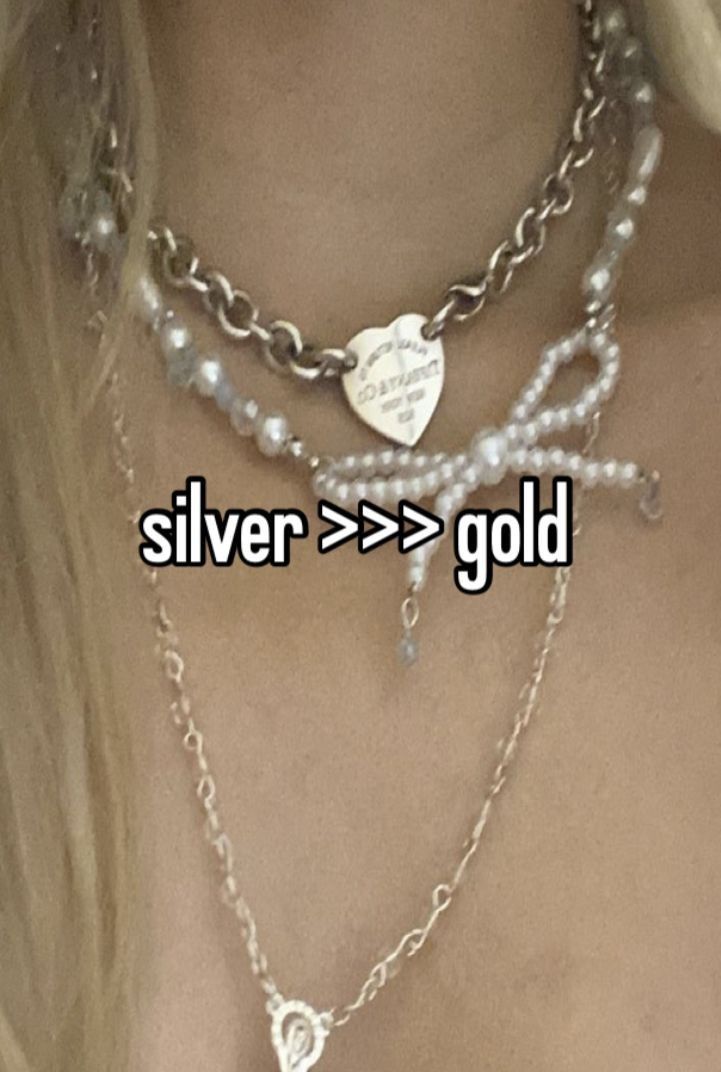 a close up of a woman's chest wearing a necklace with silver > > > > gold