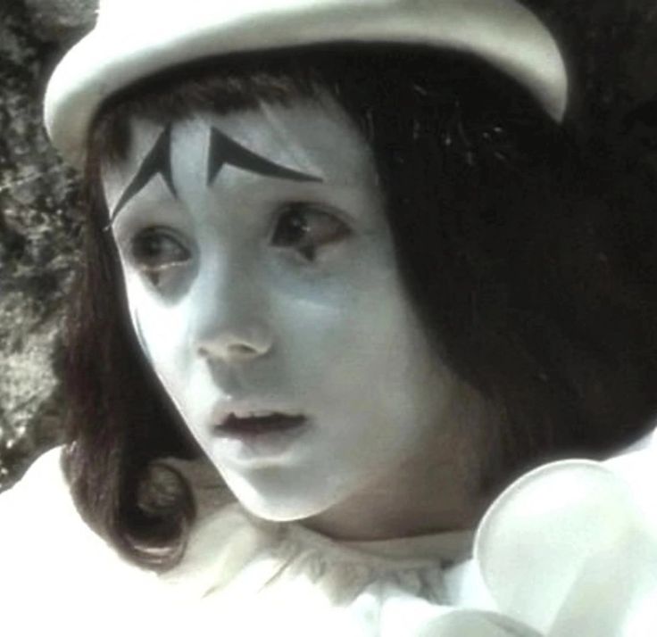 a woman with white makeup and black eyebrows wearing a sailor's hat on top of her head