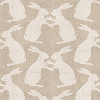 the silhouettes of rabbits are shown in white on beige linen, as well as an image