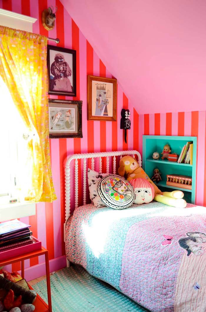 a child's bedroom with pink and orange striped walls