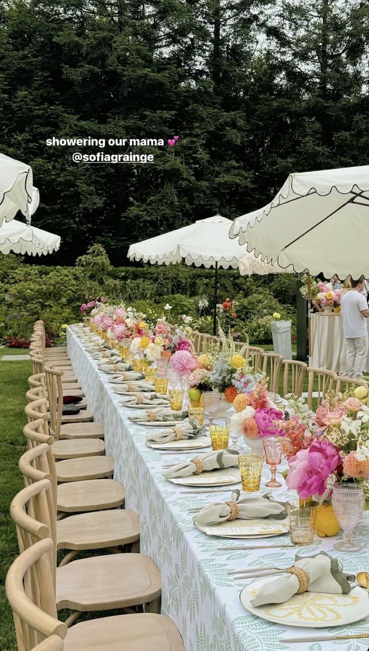 a long table is set with white and pink flowers